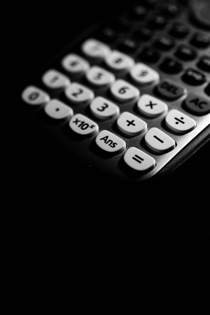 Black and white artistic shot of a calculator keypad with selective focus.