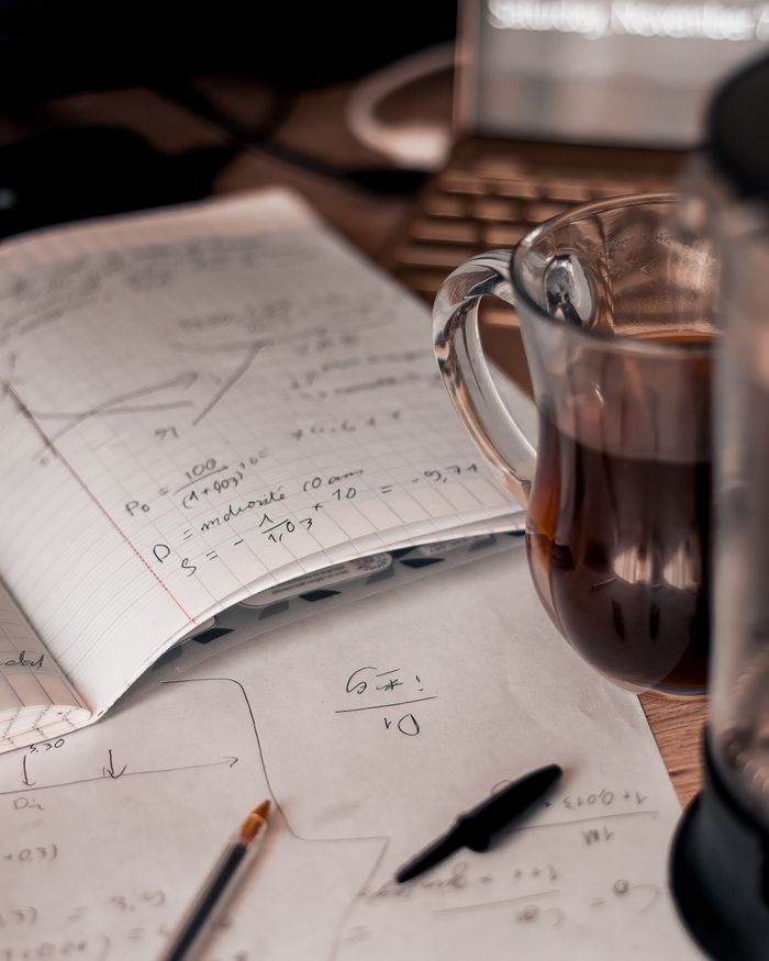 The Art of Drawing Readers In: Your attractive post title goes here An inviting workspace featuring math notes and a warm cup of coffee.